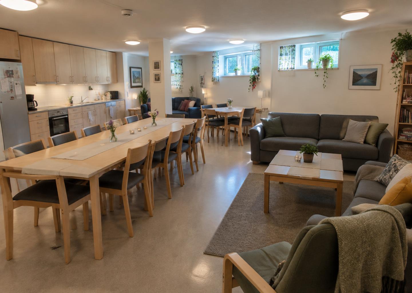 Illustrasjon: lyst selskapslokale med kjøkken, langbord og sofaer